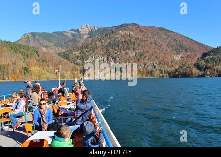 Menschen auf einer Bootsfahrt auf dem Wolfgangsee im Herbst, Österreich, Europa. Blick auf Berge und Hügel. Stockfoto