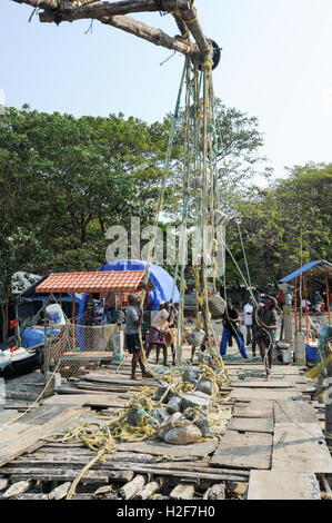 FORT KOCHI, Indien - 16. Januar 2015: Fischer betreiben eines chinesischen Fischernetz basierend auf Alter Technologie und traditioneller Materia Stockfoto