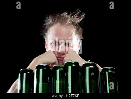 Betrunkener Mann Hangover.The und gibt eine Menge von leeren Bierdosen Stockfoto