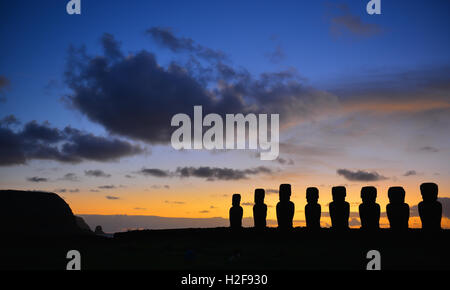 Panorama-Foto von Aku Tongariki mit den Silhouetten der Moai Statuen bei Sonnenaufgang auf der Osterinsel (Rapa Nui) im Pazifischen Ozean, Chile. Stockfoto