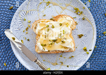 Brötchen mit Frischkäse und Honig Stockfoto