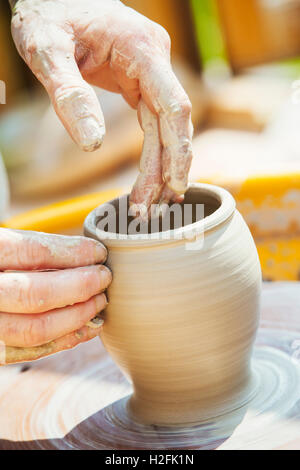 Eine Frau Töpfer arbeiten Ton auf einer Töpferscheibe in ihrer Werkstatt. Stockfoto