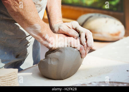 Eine Person, Potter, die Vorbereitung eines Klumpens feuchten Tones zu werfen. Stockfoto