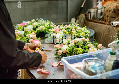 Kommerzielle Florist. Eine Frau arbeitet an einem Blumenschmuck an einer Werkbank. Stockfoto