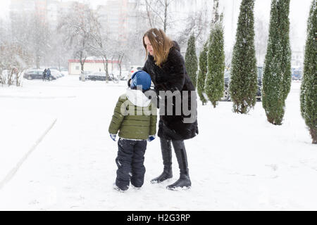 Mutter Sohn reinigt seine Nase auf einer verschneiten Straße Stockfoto