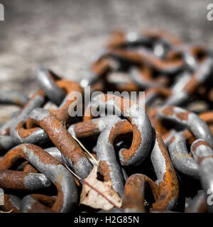 Nahaufnahme von einem Haufen von dicken verrosteten Ketten im Sonnenlicht. (Flachen DOF). Stockfoto