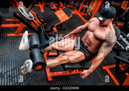 Bodybuilder tun Beinbeuger im Fitness-Studio Stockfoto