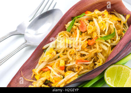 Thai Gebratene Nudeln oder gebraten Thai-Stil kleine Reisnudeln (Pad Thai) auf Banane Blüte mit Gabel und Löffel auf weiß Stockfoto