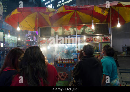 Kunden warten auf den Wagen von einem Straßenhändler verkaufen Döner, Hot Dogs und Brezeln am Times Square in New York Stockfoto