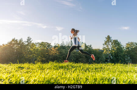 Junge Frau in Sportkleidung Joggen im Park, München, Upper Bavaria, Bavaria, Germany Stockfoto