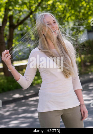 18 jährige junge Frau mit langen blonden Haaren weht Stockfoto