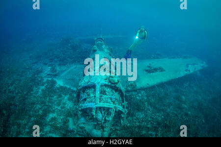 Scuba Diver erforscht eine Grumman F6F Hellcat Flugzeug abgeschossen während des 2. Weltkrieges im Pazifik-Konflikt. Stockfoto