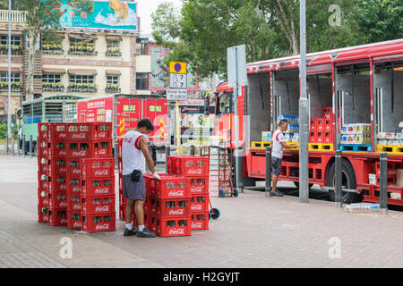 Coca-Cola-Mitarbeiter laden Flaschen auf LKW in Hong Kong Stockfoto