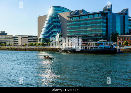 Drachenboot am Fluss Liffey Dublin Irland mit Convention Centre Dublin, Büros von Pwc und MV Cill Airne schwimmendes Restaurant Stockfoto