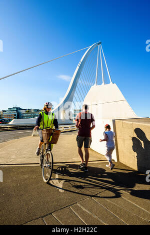 Radfahrer und Läufer am Südende von Samuel Beckett Bridge über den Fluss Liffey Dublin Irland
