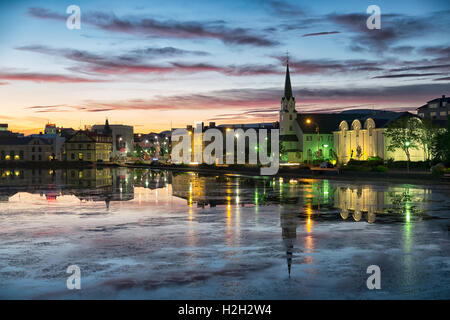 Reykjavik Teich erschossen auf einem noch Sommernacht, Rathaus von Reykjavik und andere Häuser spiegeln sich in das Stille Wasser. Stockfoto