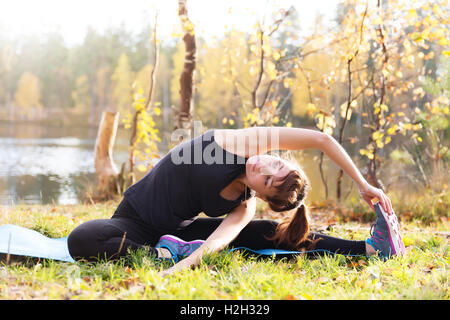 Hübsche Frau im Yoga Parivrtta Janu Sirsasana - Kopf, Knee Pose Stockfoto