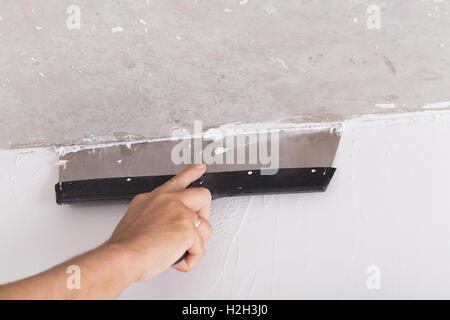 Haus Verbesserung von Arbeitskraft stellt Deckschicht der Stuck an der Wand mit einer Kelle Verputzen Stockfoto