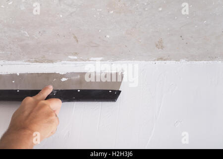 Haus Verbesserung von Arbeitskraft stellt Deckschicht der Stuck an der Wand mit einer Kelle Verputzen Stockfoto