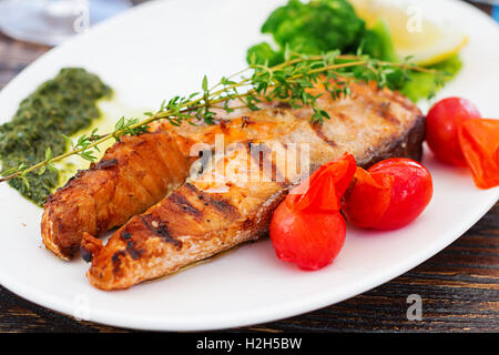 Gegrilltes Lachssteak mit Pestosauce und Gemüse Stockfoto
