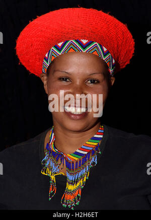 Shakaland Zulu Mädchen in eine traditionelle Zulu Hut posiert für die Kamera auf das Shakaland Cultural Village, Stockfoto