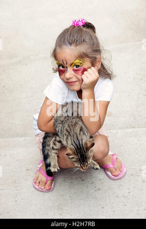 Kleines Mädchen mit Katze, Blick in die Kamera Stockfoto