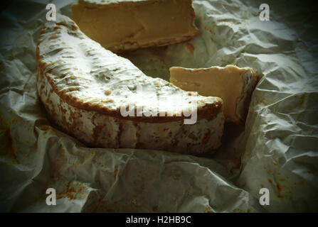 Camembert auf zerknüllte Geschenkpapier. Grunge-Stil. Stockfoto