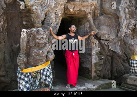 Indonesien, Bali, Goa Gajah, Tourist im Sarong posiert im Eingang C11th Elephant cave Hindu-Tempel Stockfoto
