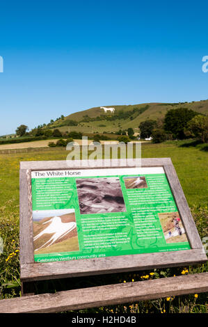 Interpretierende Zeichen über Kreidefigur Westbury White Horse, die im Hintergrund zu sehen ist. Stockfoto