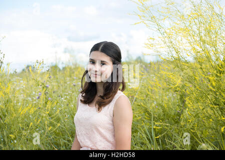 Mädchen in Guipure Kleid ruht auf Wiese Stockfoto