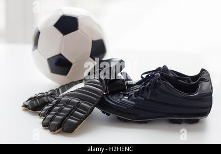 Nahaufnahme von Fußball, Stiefel und Handschuhe auf Tisch Stockfoto