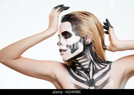 Frau mit Angst vor Halloween Make-up stehen und posiert auf weißem Hintergrund Stockfoto