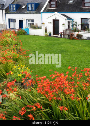 Weiße Häuschen und Sommer Crocosmia Blumen auf Iona Argyll und Bute Schottland Stockfoto