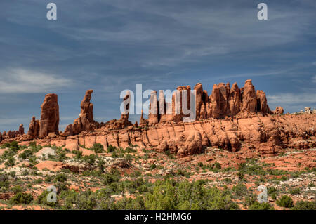 Ein paar der Männer marschieren im Bereich Klondike Bluffs des Arches National Park, Utah und drei Spalten hinter ihnen. Stockfoto