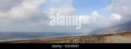 Fuerteventura, Kanarische Inseln, Nordafrika, Spanien: Der atemberaubende Blick auf den Strand Playa de Cofete vom Schmutz der Straße gesehen auf einem hohen Felsen Stockfoto