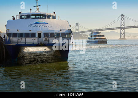 San Francisco Bay Ferry SeaCat ankern vor dem Ferry Building. Die San Francisco-Oakland Bay Bridge im Hintergrund. Stockfoto