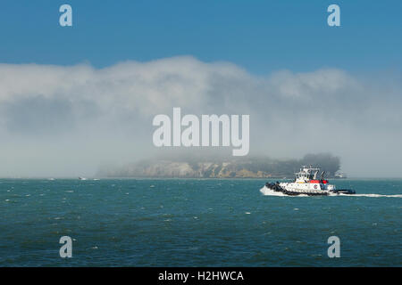 Crowley Maritime Schlepper Veteran Pässe als Seenebel Rollen über die Insel Alcatraz. Stockfoto