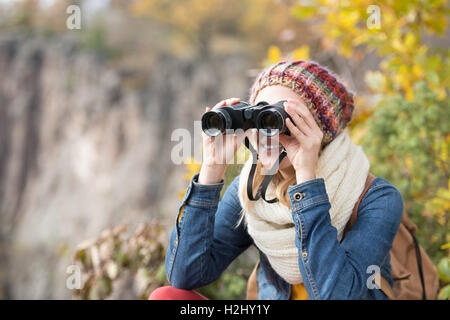 Schöne Frau, Blick durch ein Fernglas, bunten sonnigen Herbst Stockfoto