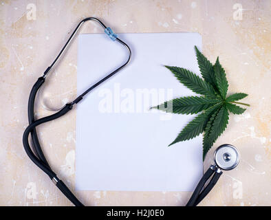 Medizinisches Marihuana Hintergrund mit leerem Papier, Cannabisblatt und Stethoskop Stockfoto