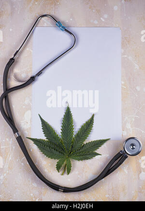 Medizinisches Marihuana Hintergrund mit leerem Papier, Cannabisblatt und Stethoskop Stockfoto