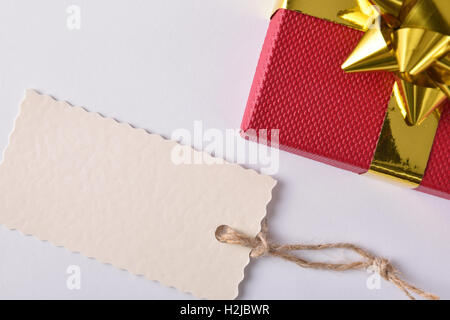 Roten Geschenkbox mit goldenen Band mit Leerzeichen auf weißem Hintergrund ab. Ansicht von oben Stockfoto