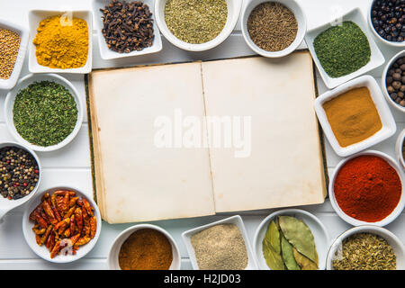 Leere Kochbuch und verschiedenen Gewürzen und Kräutern. Ansicht von oben. Stockfoto