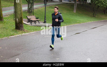 Sportlicher Mann läuft an einem regnerischen Tag. Stockfoto