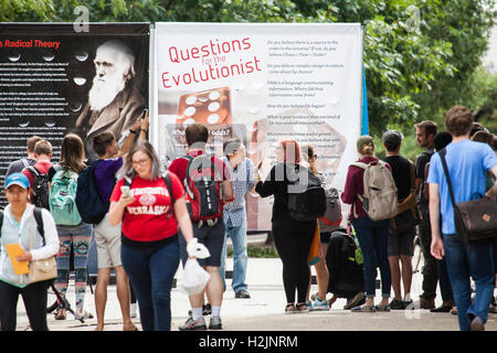 Ein Mann (Mitte) argumentiert mit einem Studenten auf dem Campus der University of Nebraska-Lincoln über die Theorie der Evolution und Darwin. Stockfoto