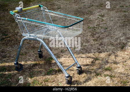 Verlassene Morrisons Einkaufswagen zurückgelassen auf einem trockenen Flecken des Grases außerhalb während des Tages Stockfoto