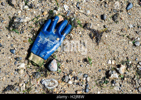 Ausrangierte Krieger Gummihandschuh verloren auf See und wusch sich am Sandstrand Stockfoto