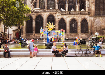 Menschen sitzen um Stravinsky-Brunnen und genießen Sie sonnige Tage in Paris. Es gibt viele zeitgenössische Kunstwerke in den Pool. Stockfoto