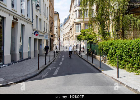 Frau Fahrrad auf einer der Straßen in Le Marais Bezirk von Paris. Wir sehen Menschen Wander- und französische Baustile in bu Stockfoto