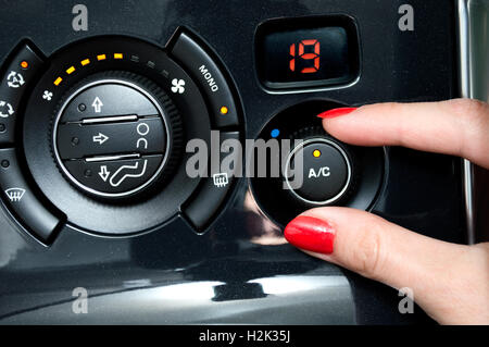 Frau stellt sich auf eine Klimaanlage im Auto Stockfoto