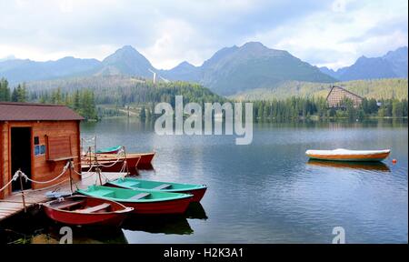 Kleine Boote am Pier am Bergsee in Strbske Pleso, hohe Tatra Gebirge. Stockfoto